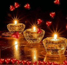 three lit candles are surrounded by red hearts on a black background