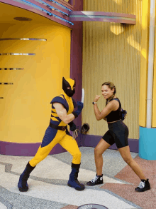 a man in a wolverine costume is standing next to a woman