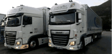 two white trucks are parked next to each other with akgul written on the side