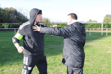 a man in a hooded sweatshirt with adidas on the sleeves