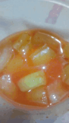 a close up of a bowl of iced tea with sliced fruit