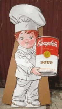 a boy in a chef 's hat is holding a can of campbell 's soup .