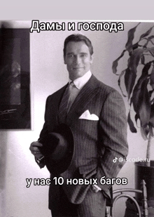 arnold schwarzenegger in a suit and tie holding a hat with a caption in russian