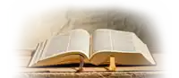 an open bible with a yellow bookmark on a table