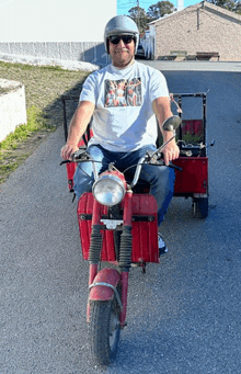 a man wearing a helmet and sunglasses is riding a red scooter