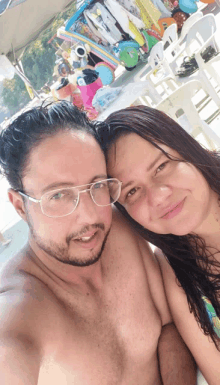 a man and a woman are posing for a picture on a beach