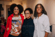 three women are posing for a picture and one of them is wearing glasses