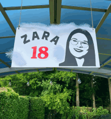 a sign that says zara 18 with a picture of a girl on it