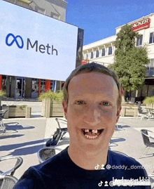 a man taking a selfie in front of a sign that says meth