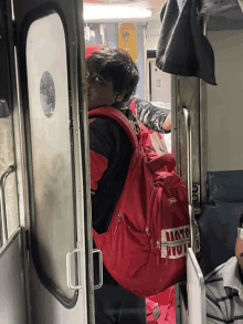 a person with a red backpack that says ' marvel ' on the front