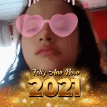 a girl wearing pink heart shaped sunglasses with the year 2021 written on it .