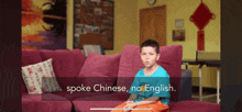 a young boy sits on a couch with the words spoke chinese no english written on the bottom