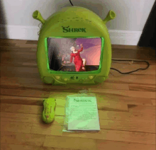 a shrek tv sits next to a shrek remote