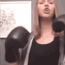 a woman is wearing boxing gloves and singing .