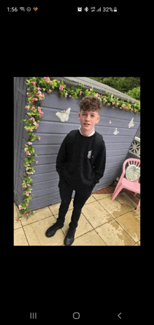 a young boy is standing in front of a shed with butterflies on it