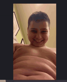 a young boy without a shirt is smiling with his belly showing