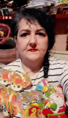 a woman in a striped shirt is holding a stuffed animal that says ' christmas ' on it