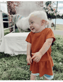 a little girl stands in front of a white horse