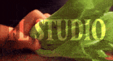 a person is holding a green leaf and the word el studio is visible