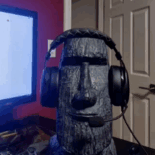 a statue of a moai wearing headphones with a microphone