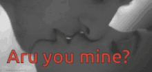 a black and white photo of a couple kissing with the words " are you mine " written in red