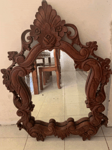 a wooden mirror with a floral design on it