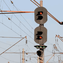 a row of traffic lights on a pole with one that is red