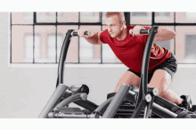 a man in a red shirt is doing exercises on a machine