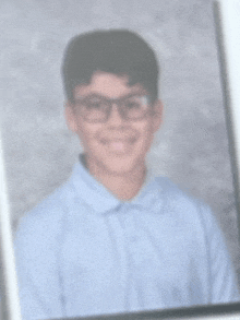 a blurry picture of a young boy wearing glasses