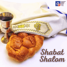 a picture of a loaf of bread and a cup of wine with the words shabat shalom