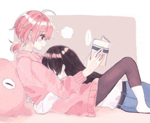 a girl is reading a book to another girl while they are laying on a bed .