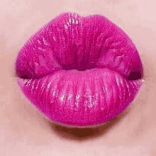 a close up of a woman 's lips with pink lipstick on .