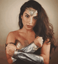 a woman in a wonder woman costume is posing for a picture with her hands on her chest .