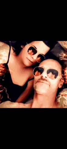 a man and a woman wearing sunglasses are posing for a picture