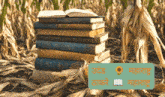 a stack of books sits in the middle of a corn field with a sign that says ' maharashtra ' on it