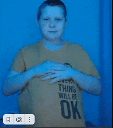 a young boy wearing a shirt that says everything will be ok