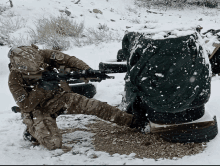 a soldier is kneeling down in the snow while holding a gun and wearing a helmet that says us air force