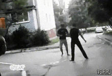 a black and white photo of two men fighting on a street with the words break vgif.ru on the bottom