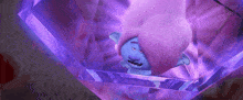 a troll with purple hair is laying in a purple cube .