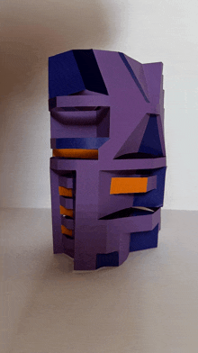 a purple and orange sculpture on a table with a white background