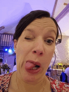 a woman making a funny face with her eyes closed and her tongue sticking out