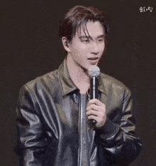 a man in a leather jacket is holding a microphone