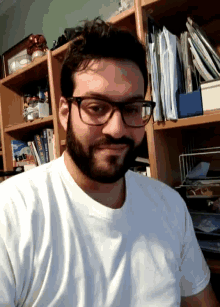 a man wearing glasses and a white shirt stands in front of a bookshelf with a book called tab on it