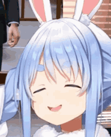 a close up of a girl with bunny ears and blue hair smiling .