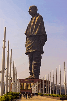 a statue of a man standing in front of a row of poles