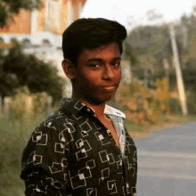 a young man wearing a black shirt with white squares on it