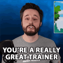 a man with a beard is talking into a microphone with the words you 're a really great trainer behind him