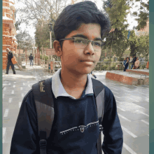 a young man wearing glasses and a sweatshirt that says " village "