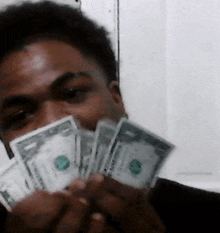 a man holding a bunch of dollar bills in his hands