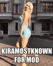 a woman in a blue dress is standing in front of a building with a caption that says `` kiramostknown for mod '' .